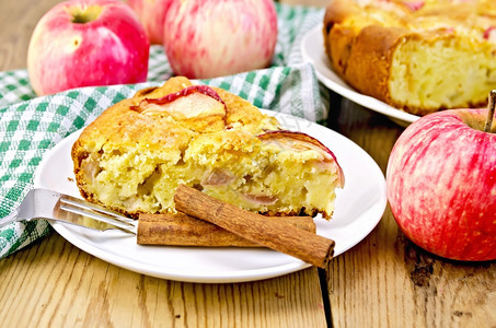 甜苹果派和肉桂放在方格餐巾和木板背景上图片