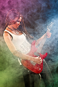 时的美国女孩吉他弹硬摇滚黑色背景的彩雾和光亮图片