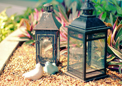 装饰花园的陶瓷鸟和旧灯具有反转过滤效应图片