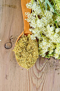 木制勺子配有干枯的草地蜂蜜花朵木制板上一束草地蜂蜜鲜花图片