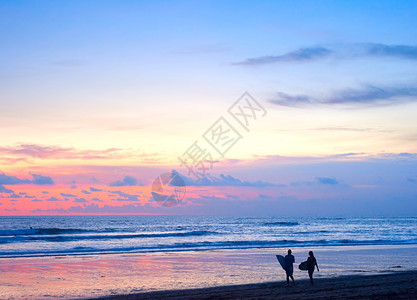 冲浪者在巴厘岛海滩上行走图片