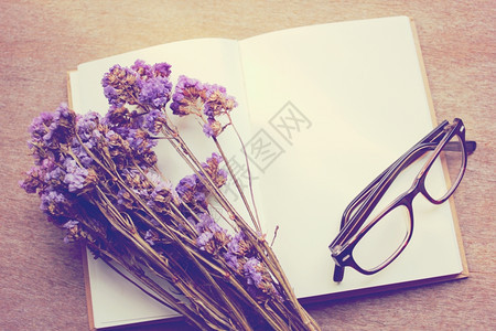 白色笔记本上的紫色干花图片