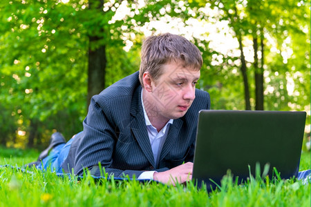 商人在草地上用电脑工作图片
