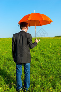男子在野外与橙色雨伞图片