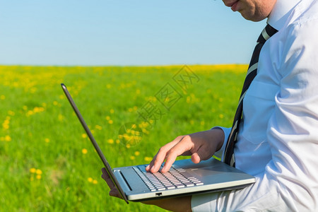 男人与笔记本电脑在自然界的领带图片