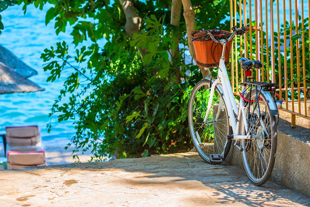 白色自行车停在海边码头的栅栏边上图片
