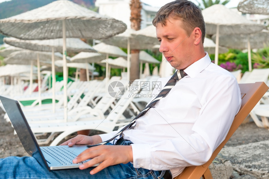 在海滩上做笔记本电脑的经理图片