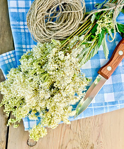 一束鲜花用刀子和绳套在木板背景上的餐巾纸图片