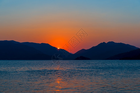 美的海景日出在平静的海面上图片