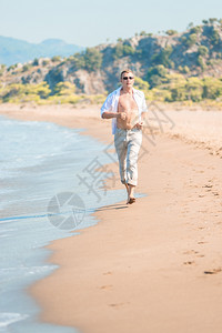 在岸边跑步的男子垂直图片