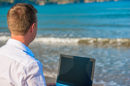 在海后视线用笔记本电脑的人图片