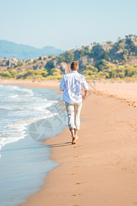 男人赤脚在海滩上漫步图片