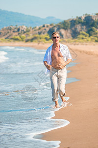 身穿内衣的男沿着海岸奔跑图片