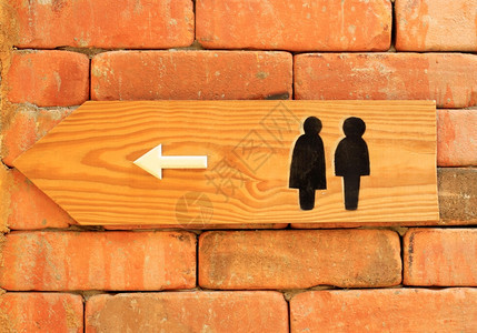 砖墙上的厕所标志和方向图片