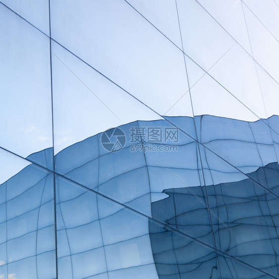 具有蓝色天空和玻璃墙反射力的现代玻璃建筑图片
