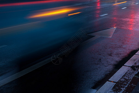带交通灯和超速车辆反光射的湿路图片