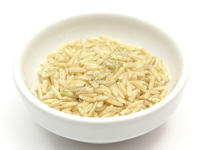 白种背景的一碗水稻的棕色大米图片