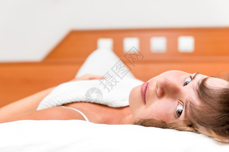 笑着的年轻美女睡在床上图片