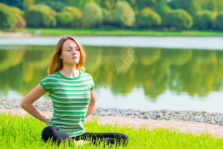 女在草地上做瑜伽图片