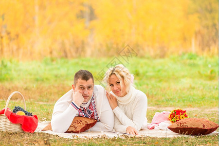 秋天年轻夫妇在公园野餐图片