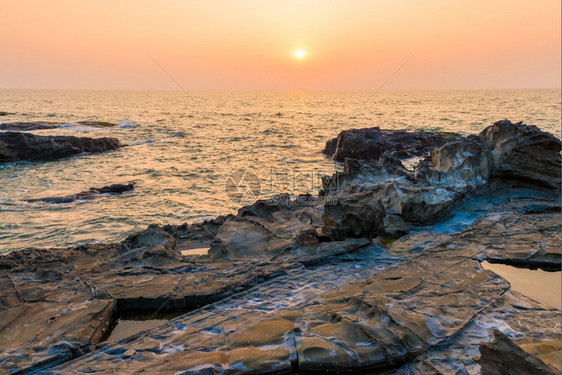 海和岩石日落时美丽的风景图片