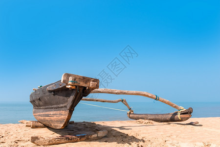 热带海滩上的老木头渔船图片