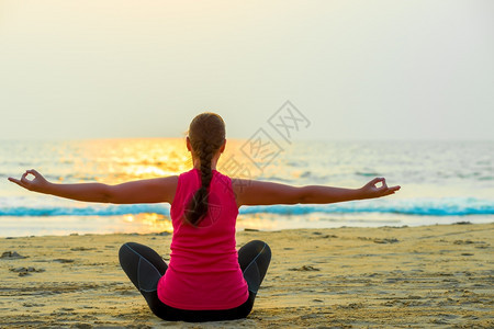 单女人在海边日落时做瑜伽图片