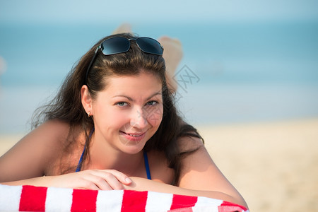 美丽的年轻女躺在海边的休息室图片