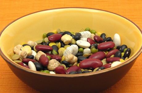对一碗陶瓷中的混合和彩色豆子的近视图片