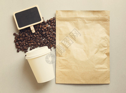 装有纸杯反转过滤效果的咖啡袋和空白黑板图片