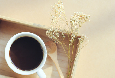 黑咖啡和木板上勺子带干鲜花反转过滤效应图片