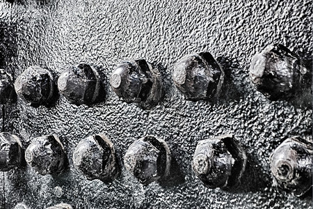 黑色钢结构螺栓和刺线黑钢结构的工业抽象背景纹理图片