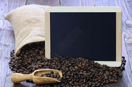 咖啡豆和黑板放在木制桌子上的咖啡豆图片