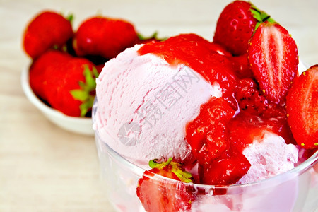 草莓冰淇淋在玻璃碗草莓中的在布的盘子上图片