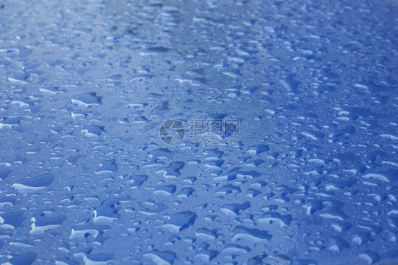 闪亮蓝色表面的雨滴模式图片