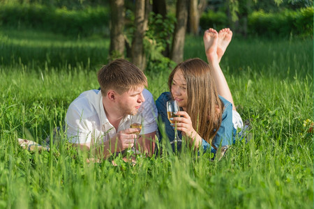 男女躺在草地上喝着酒野餐图片