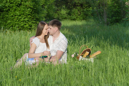 在城市公园野餐时抱草地的情侣女孩和男图片