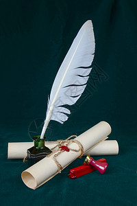 墨水井中的白色羽毛密封蜡标志和两张纸卷图片