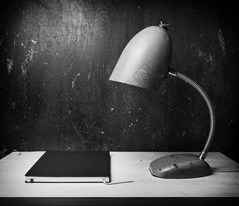 书桌台灯办公桌上的笔记本和台灯背景