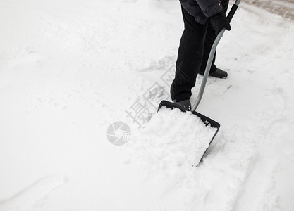 冬天用雪铁铲打扫人行道的图片