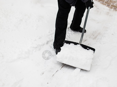 冬天用雪铁铲打扫人行道的图片