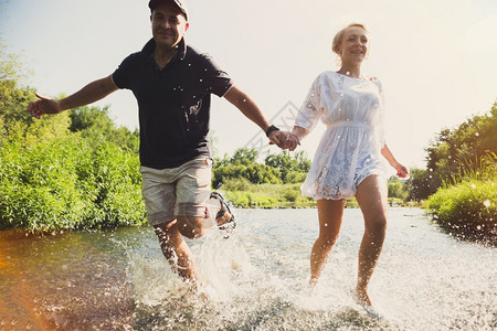 快乐的情侣在水中奔跑图片
