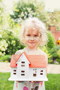 手持木制房屋模型的小女孩图片