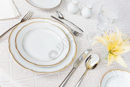 漂亮的装饰桌上面有白色板水晶眼镜餐具和豪华桌布上的鲜花图片