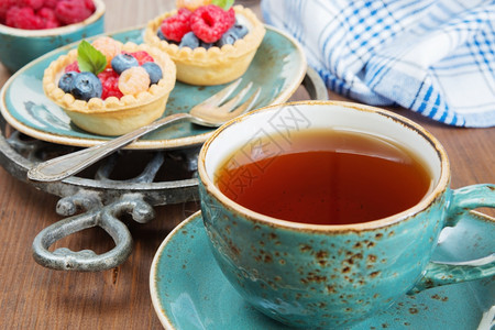 蓝色古年茶杯中的黑和果子配有草莓和蓝图片