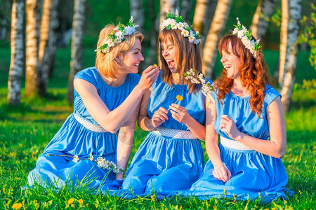 三个女孩在草坪上穿着同等衣服玩得开心图片