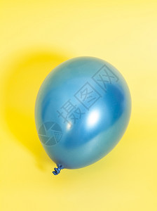 黄色背景的蓝充气球图片