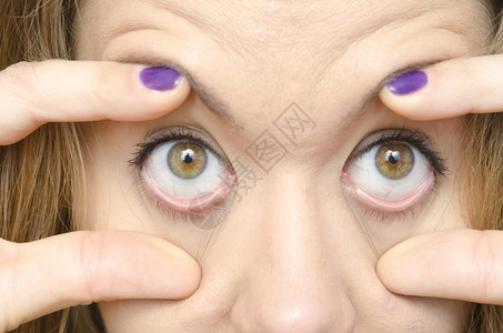 打开的手女人用手指扒开眼睛背景