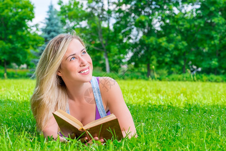 女孩在公园的草地上看书图片