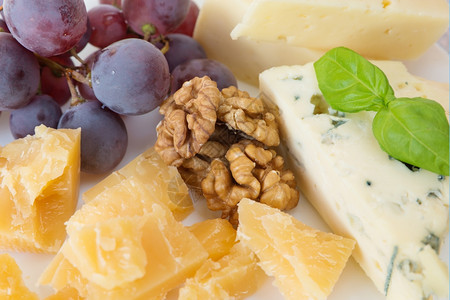 不同种类的奶酪胡桃红葡萄和叶图片